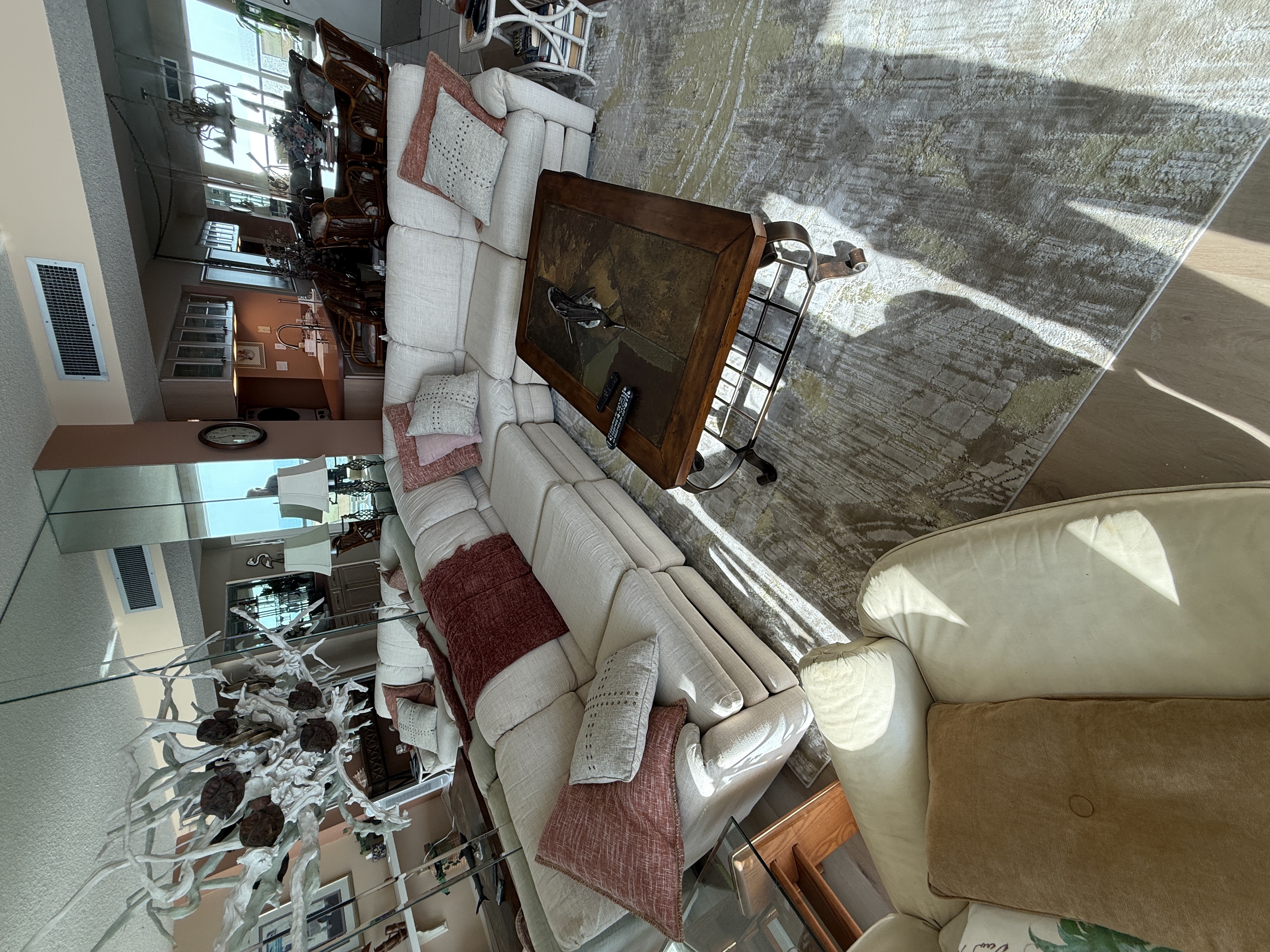 Living room with mirror wall and kitchen beyond